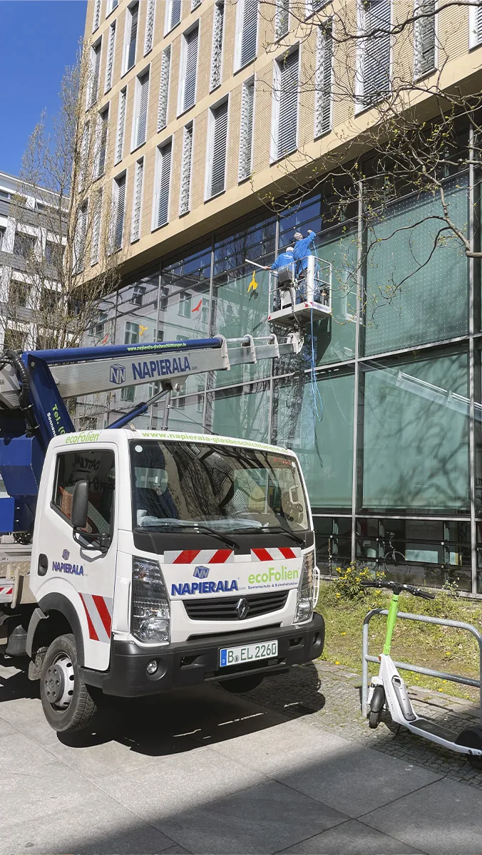 Montage von Vogelschutzfolie an einer Glasfassade mit Hubarbeitsbühne
